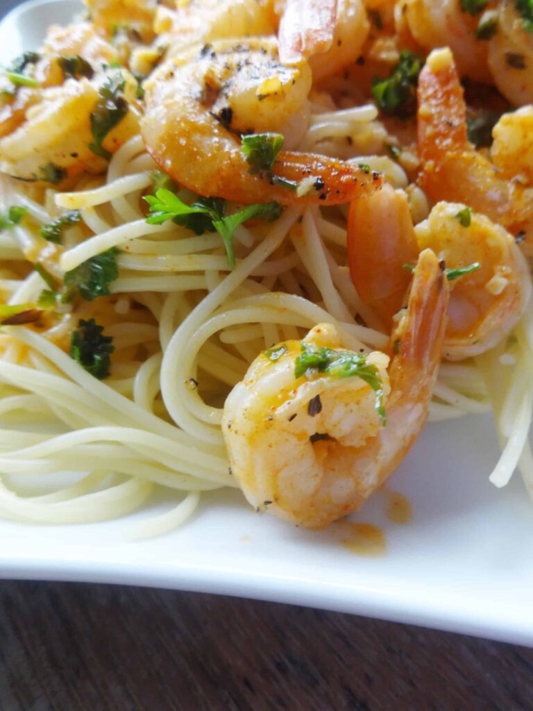 Tail-on shrimp served over pasta